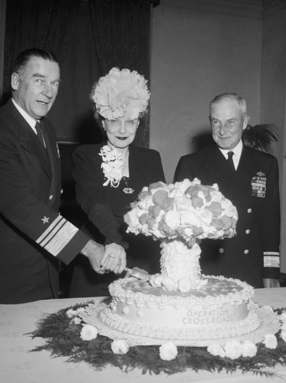 Admiral William H.P. Blandy and his wife cut an Operation Crossroads mushroom cloud cake, while Admiral Frank J. Lowry looks on. 7 November 1946
