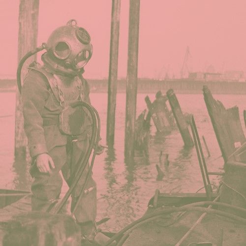 Historisches Foto eines Arbeiters mit Maske und Schläuchen.