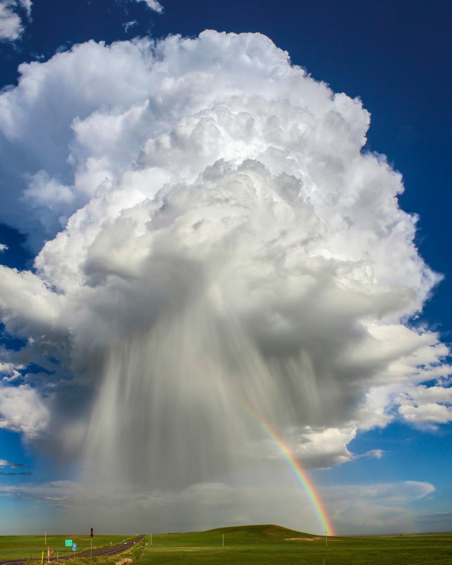 Große Regenwolke am Himmel und ein Regenbogen.